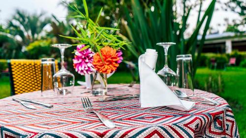 a table with a table cloth with flowers and wine glasses at Room in Guest room - Isange Paradise Resort in Ruhengeri