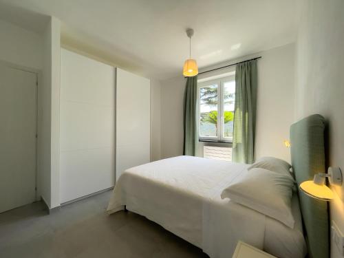sypialnia z białym łóżkiem i oknem w obiekcie Podere Belvedere w mieście Moneglia