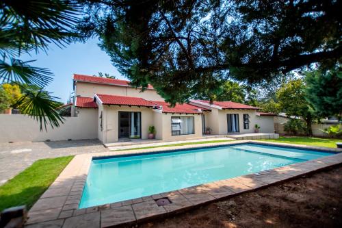 a swimming pool in front of a house at Prestigious Apartments in Fourways