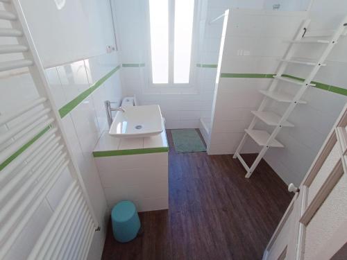 Elle comprend une petite salle de bains pourvue d'un lavabo et d'une étagère. dans l'établissement Maison Provençale, à La Seyne-sur-Mer