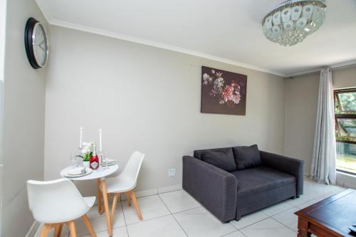 a living room with a couch and a table at Prestigious Apartments in Fourways