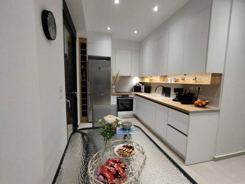 a kitchen with a table with a bowl of fruit on it at Brand new flat with courtyard and private parking! in Athens