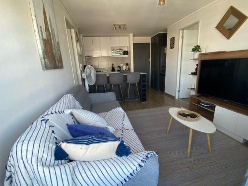 a living room with a couch and a television at Precioso departamento amueblado 2 habitaciones + 2 baños in Los Ángeles