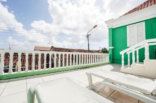 a green and white house with a bench on a roof at Atelier Skalo Boutique Hotel in Willemstad
