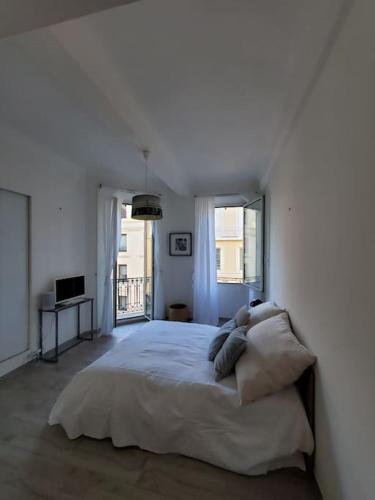 - une chambre blanche avec un grand lit et 2 oreillers dans l'établissement Appartement Rue d'Antibes, à Cannes