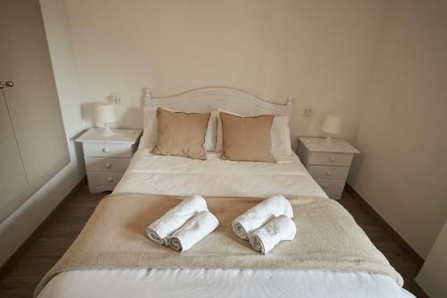ein Schlafzimmer mit einem Bett mit zwei Handtüchern darauf in der Unterkunft Céntrico apartamento Playa de San Juan Alicante in Alicante