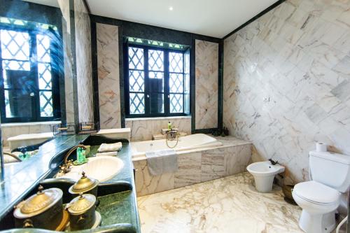 a bathroom with a sink and a tub and a toilet at Appartement privé dans une grande maison d'hote in La Marsa