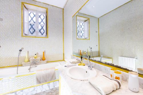 a bathroom with a sink and a tub and a mirror at Appartement privé dans une grande maison d'hote in La Marsa