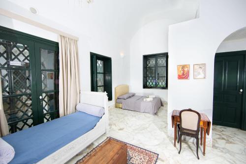 a bedroom with a bed and a table and chairs at Appartement privé dans une grande maison d'hote in La Marsa