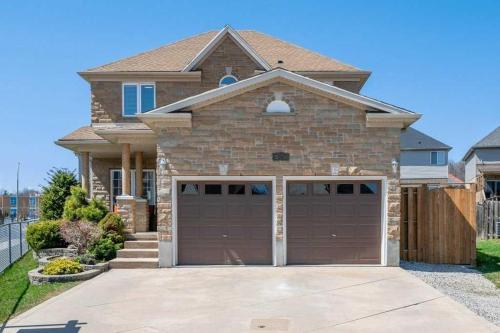 uma casa com uma porta de garagem castanha em frente em Comfortable Modern Room near YKF Airport III em Kitchener