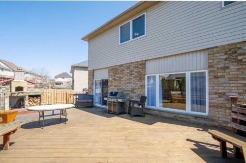 a patio with a table and a grill and a house at Comfortable Modern Room near YKF Airport III in Kitchener