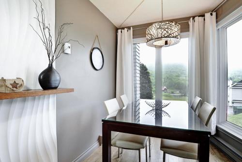 a dining room with a glass table and a window at 22#31 Chemin du Hameau - Studio in Stoneham