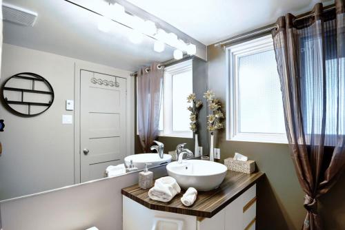 uma casa de banho com um lavatório e um espelho grande em 22#31 Chemin du Hameau - Studio em Stoneham