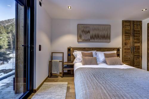 a bedroom with a bed and a large window at Chalet Green Forest in Chamonix-Mont-Blanc