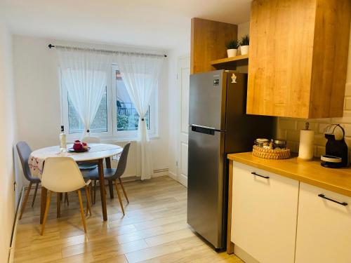 uma cozinha com uma mesa e um frigorífico de aço inoxidável em Schei Residence em Brasov