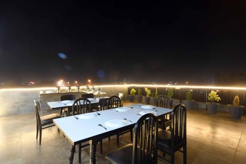 a restaurant with tables and chairs on a balcony at night at Aceotel Select Tulsi Vijay Nagar in Indore