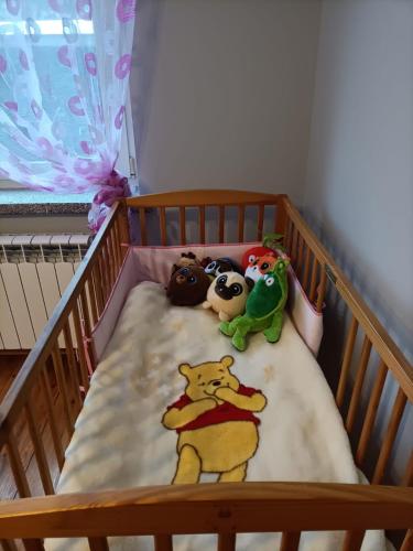 a crib with three stuffed animals on a blanket at Noclegi w Dolinie Drwęcy in Kurzętnik