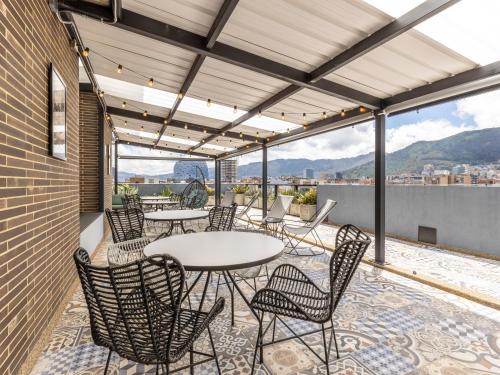 a patio with tables and chairs on a roof at Life by Wynwood House in Bogotá