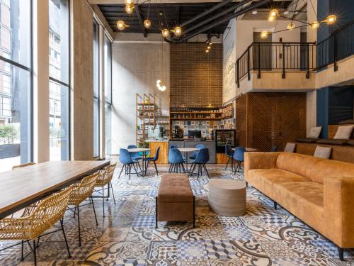 a lobby with a couch and tables and chairs at Life by Wynwood House in Bogotá