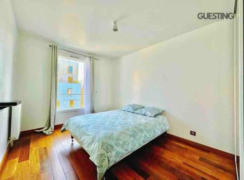 um quarto com uma cama e uma grande janela em Top Apartment Île St-Denis aux Portes de Paris em Saint-Ouen