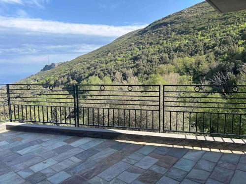 a black fence with a mountain in the background at Villa de charme vue mer in Brando