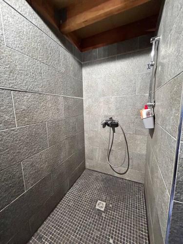 La salle de bains est pourvue d'une douche et de carrelage. dans l'établissement Villa de charme vue mer, à Brando