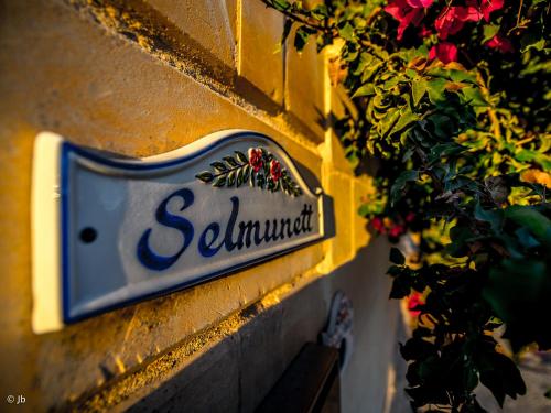 een bord aan de zijkant van een gebouw met bloemen bij Villa Selmunett in Naxxar