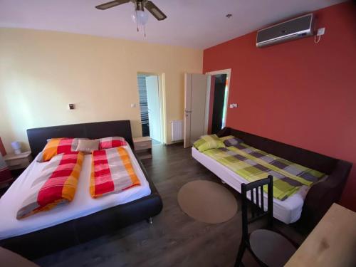 Borostyán Apartmanház في موراهالوم: غرفة نوم بسريرين وطاولة فيها