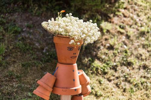 a statue of a flower pot with flowers in it at Frühstückspension Rötelstein in Ramsau am Dachstein