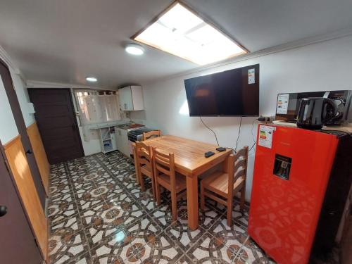 a kitchen with a table and a red refrigerator at Departamento interior 2 Villarrica Céntrico in Villarrica