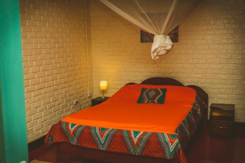 a room with a bed with an orange blanket at Room in Guest room - Isange Paradise Resort in Ruhengeri