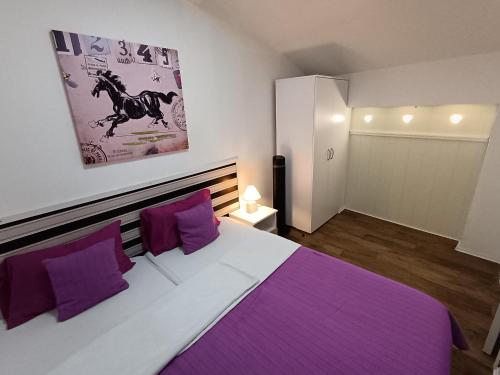 um quarto com uma cama grande e almofadas roxas em Apartments Vladika - Oldtown em Novi Sad