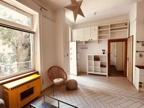 Chestnut Home - a charming and warm feel place في بودابست: غرفة معيشة مع نافذة كبيرة ومطبخ