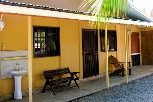 een geel huis met een bank en een wastafel bij Dominga's Eco-Yellow Hideaway in Puerto Viejo