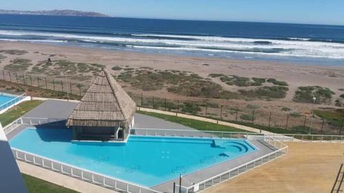 an overhead view of a swimming pool next to the beach at Apartamento en Laguna del Mar in La Serena