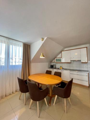 a kitchen with a wooden table and chairs in a room at Aparthotel Gaja in Bled