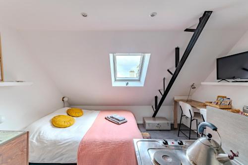 ein Schlafzimmer mit einem Waschbecken und einem Bett mit gelben Kissen in der Unterkunft Charmant studio à deux pas de la gare - Le Nichoir in Rennes