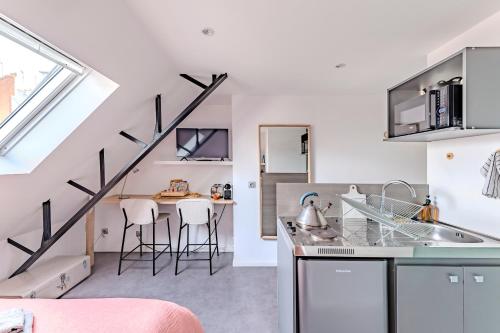 une cuisine et une salle à manger avec un escalier en mezzanine dans l'établissement Charmant studio à deux pas de la gare - Le Nichoir, à Rennes
