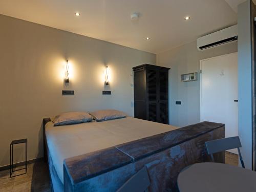 1 dormitorio con 1 cama y 2 luces en la pared en Luxe kamer B&B Gezond aan Zee, met jacuzzi en stoomsauna, de wellnestuin buiten is te huur voor privé gebruik tegen meerprijs, en Ouddorp