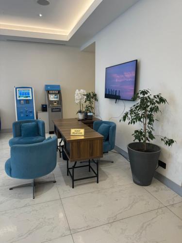 a waiting room with a table and chairs and a tv at Orbi city - Premium Class Rooms in Batumi