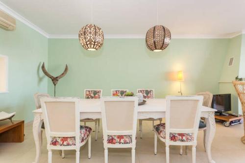 a dining room with a white table and chairs at Casa Romeo y Julieta in Castro Marim