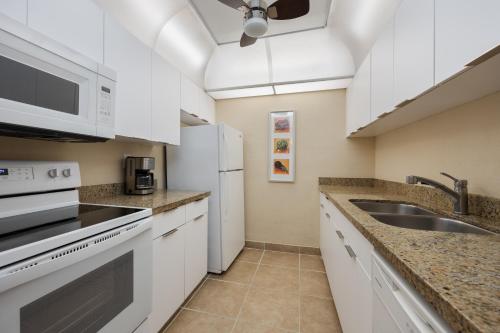 a kitchen with white cabinets and a sink at Coconut Bay Resort in Fort Lauderdale