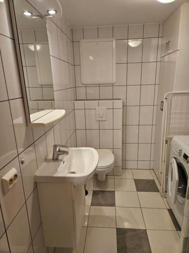 a bathroom with a sink and a toilet and a mirror at Leilighet nær flyplass og Ålesund sentrum in Ytterland