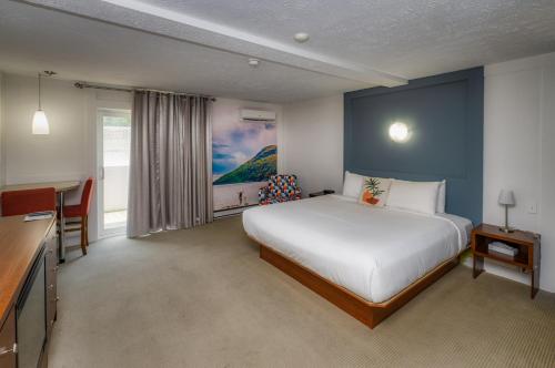 a hotel room with a bed and a desk and a kitchen at Clarion Pointe La Malbaie in La Malbaie