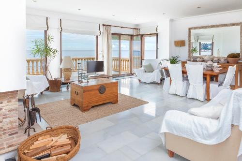 a living room with a television and a table and chairs at Mar-Beach front apartment in Jávea in Jávea