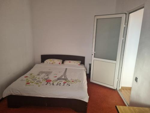 a bedroom with a bed and a sliding glass door at Apartament Unirii Belvedere in Baia Mare
