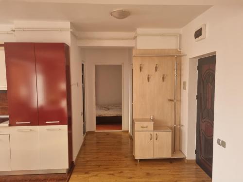 La cuisine est équipée de placards blancs et d'un réfrigérateur rouge. dans l'établissement Apartament Unirii Belvedere, à Baia Mare