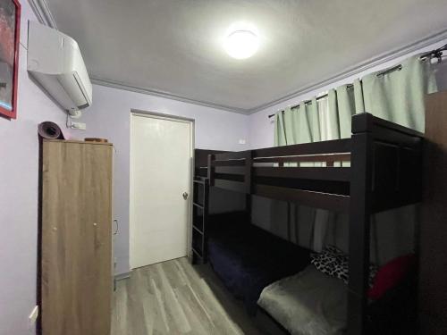 ein Schlafzimmer mit einem Etagenbett und einer Tür in der Unterkunft Camella Cerritos Gensan in General Santos