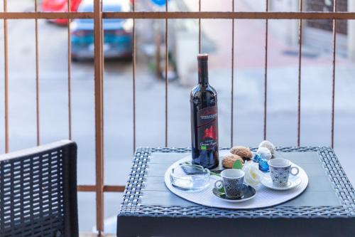 a bottle of wine and two cups on a table at saige holidays in Alghero