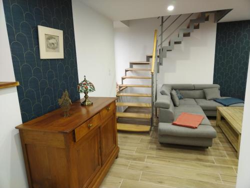 a living room with a couch and a staircase at La fermette paisible proche du Mont Saint-Michel in Saint-James